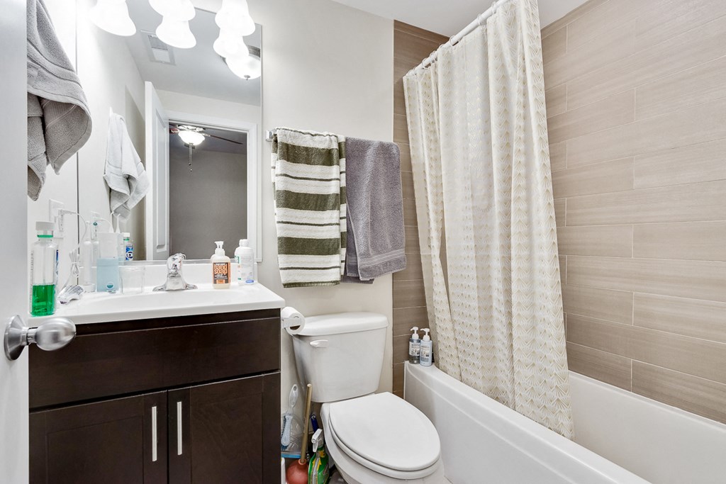 a bathroom with a toilet sink and shower and a mirror