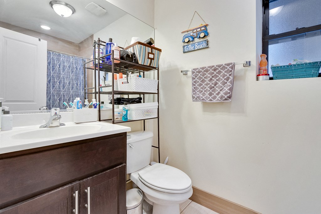 a bathroom with a toilet and sink and a window