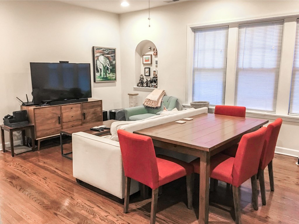 a dining room and living room with a table and chairs and a television