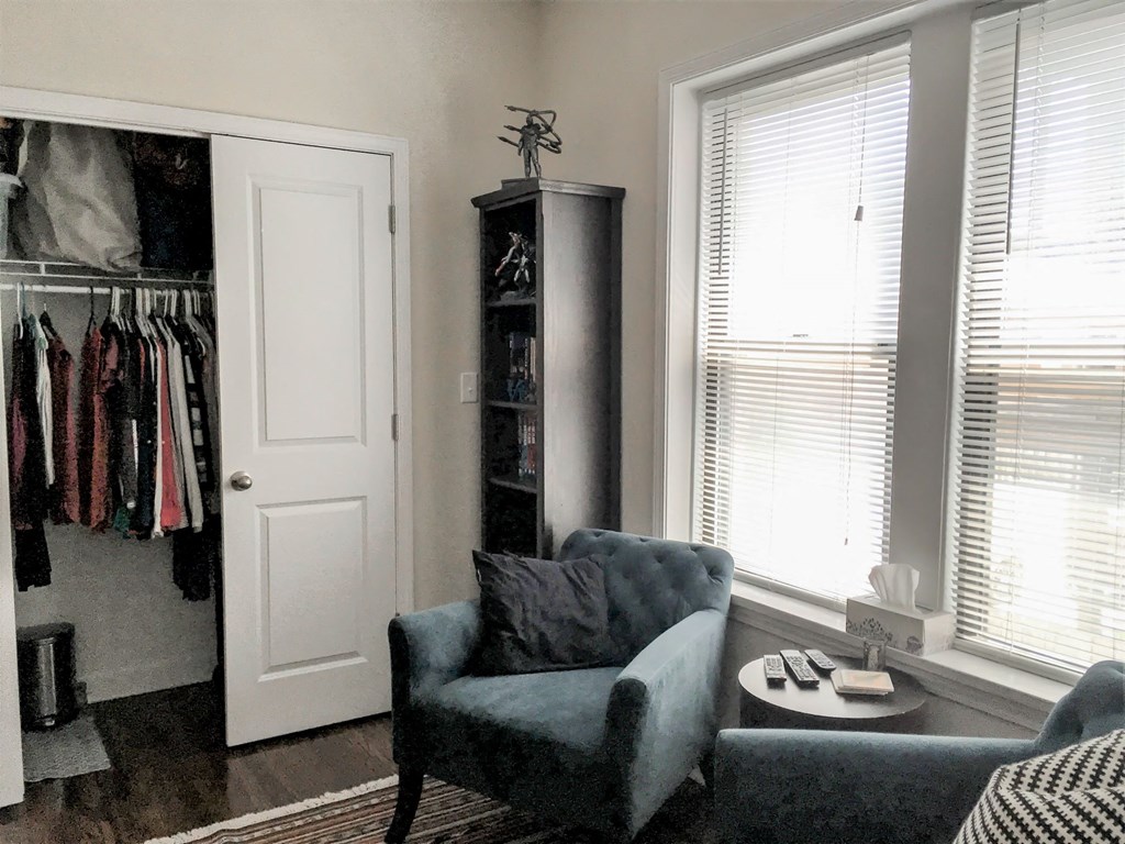 a living room with a closet and a chair and a table