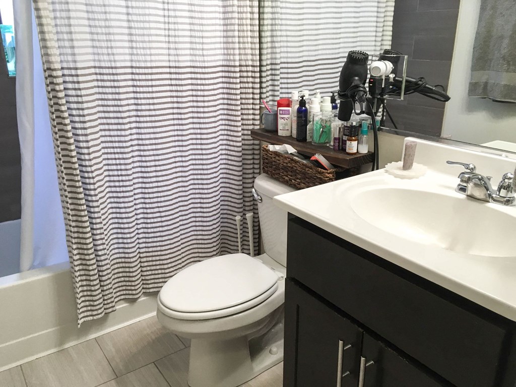 a bathroom with a toilet and a sink and a shower curtain