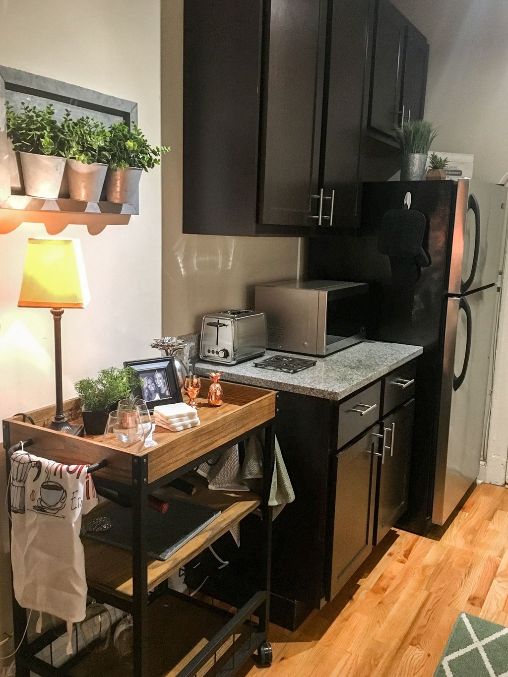 a small kitchen with black cabinets and a table with plants
