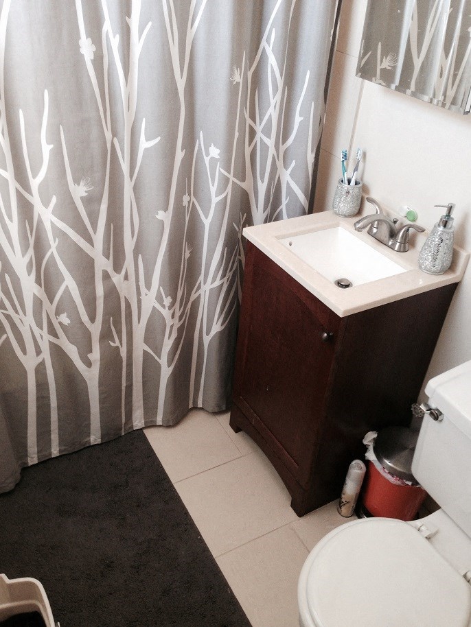 a bathroom with a sink and a toilet and a shower curtain