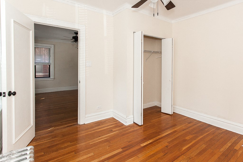a bedroom with a closet and a hard wood floor