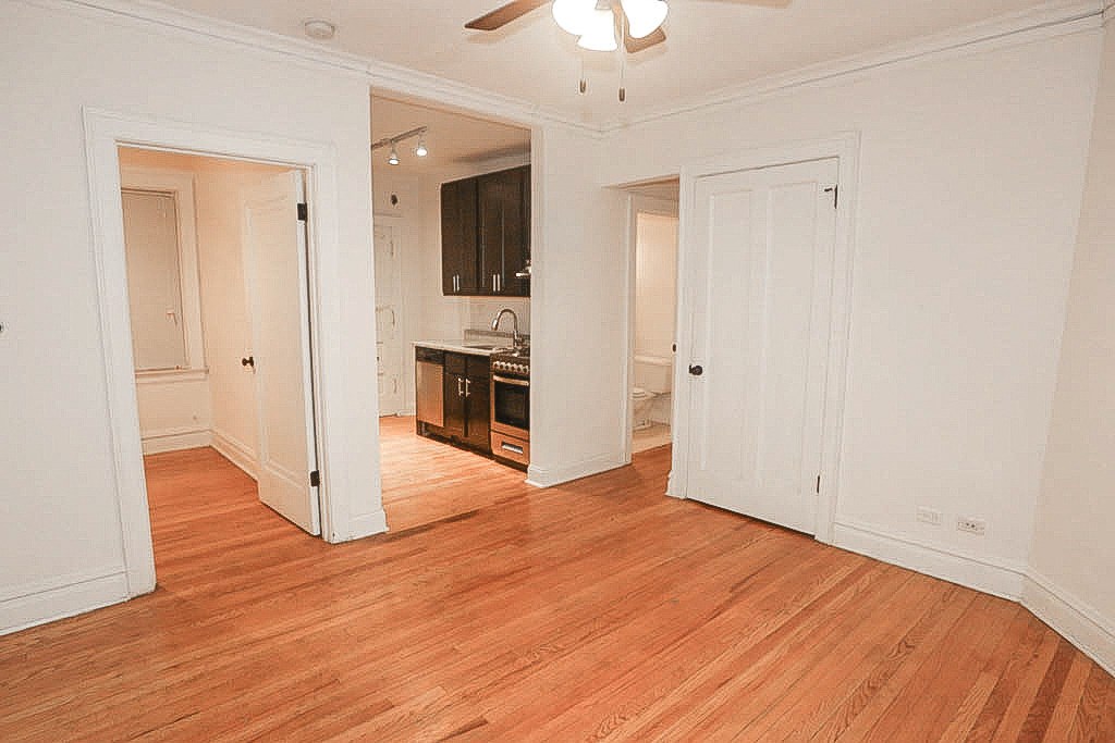 a living room and a kitchen with a wood floor