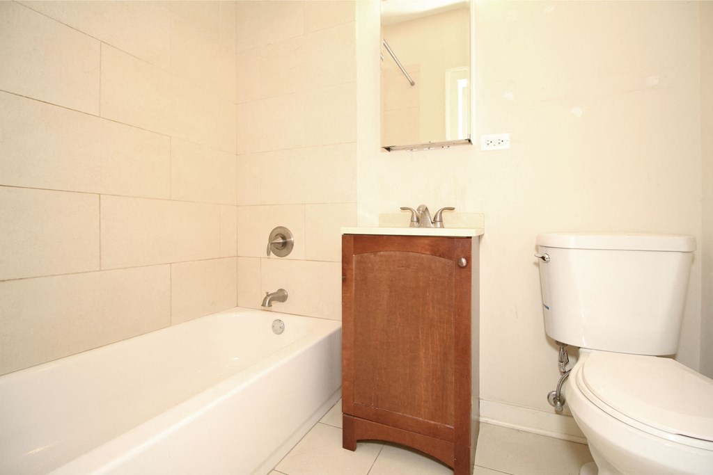 a bathroom with a toilet sink and tub and a mirror