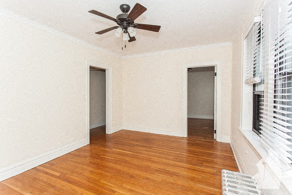 a living room with a ceiling fan and a wood floor