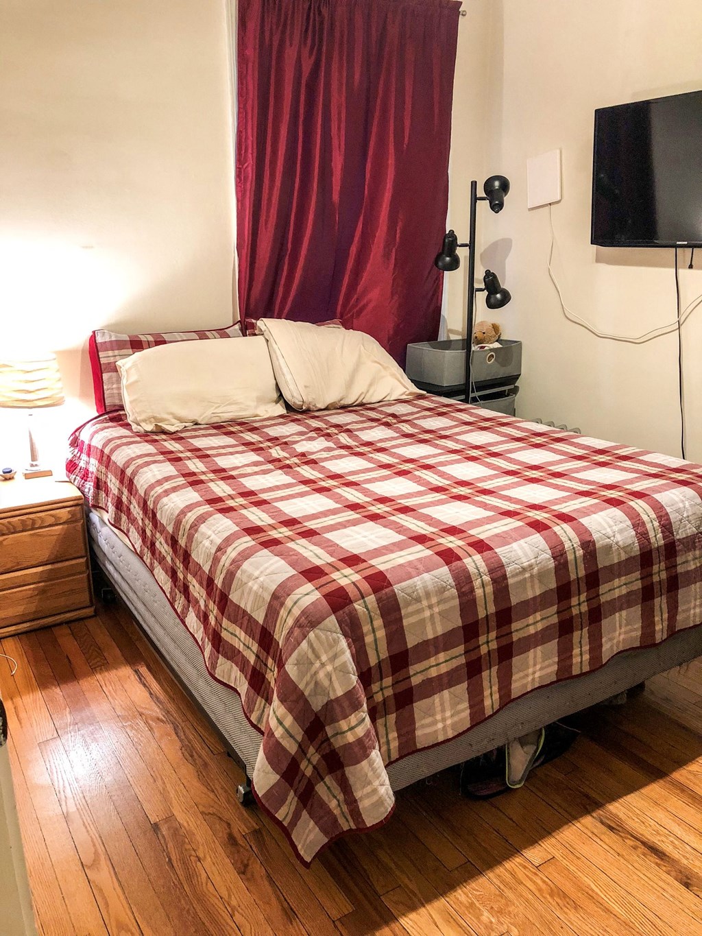 a bed with a red and white checkered comforter in a bedroom