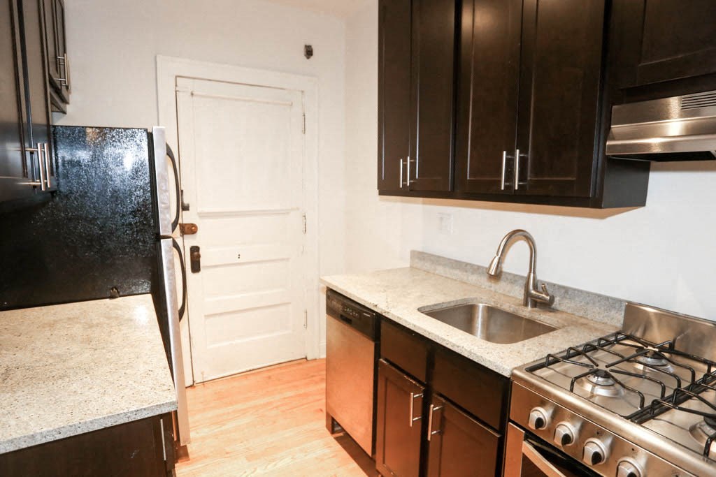 a kitchen with a sink and a refrigerator and a door