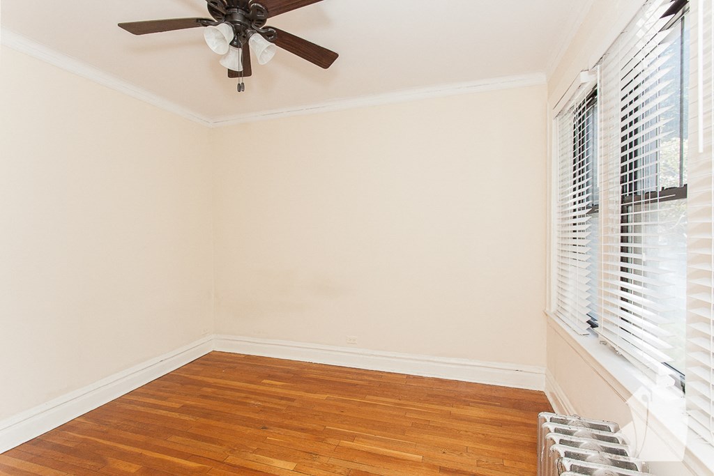 an empty room with a ceiling fan and a window