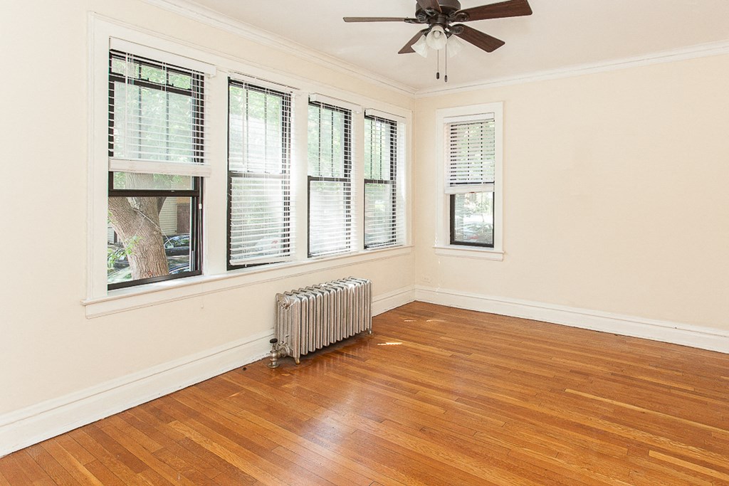 an empty living room with a radiator and windows