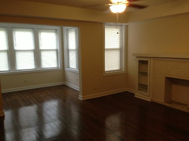a living room with a hard wood floor and a fireplace