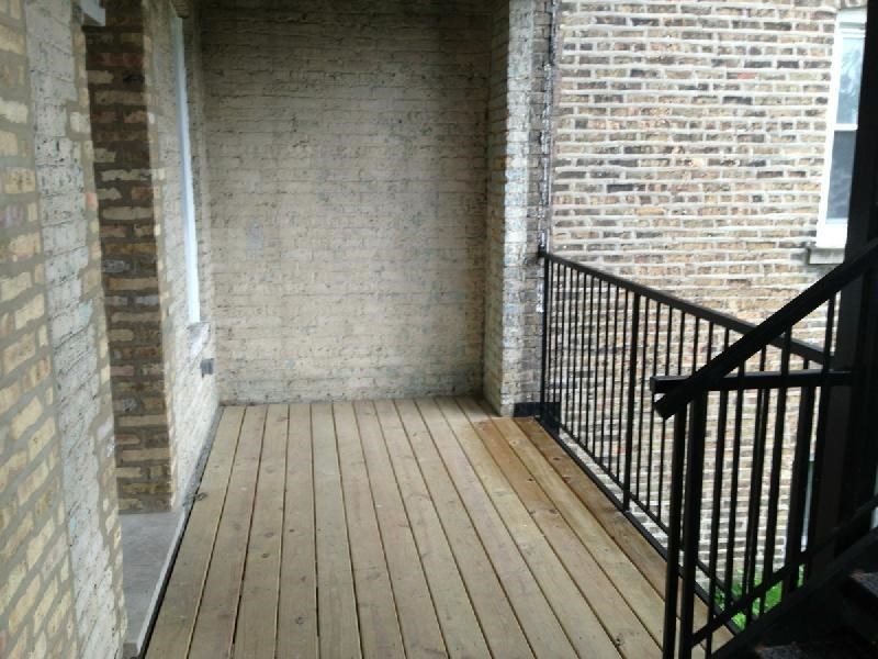 a wooden deck in front of a brick building