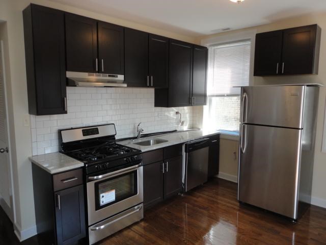 a kitchen with black cabinets and stainless steel appliances