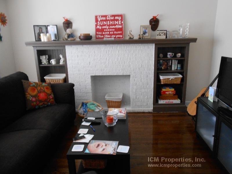 a living room with a couch and a coffee table and a fireplace