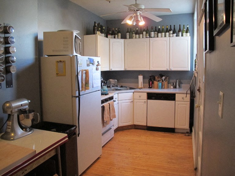 a kitchen with white cabinets and a refrigerator
