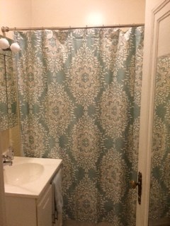 a bathroom with a shower curtain and a sink