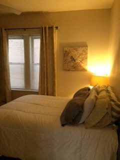 a bedroom with a bed and a lamp and a window