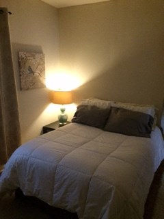 a small bedroom with a bed and a lamp