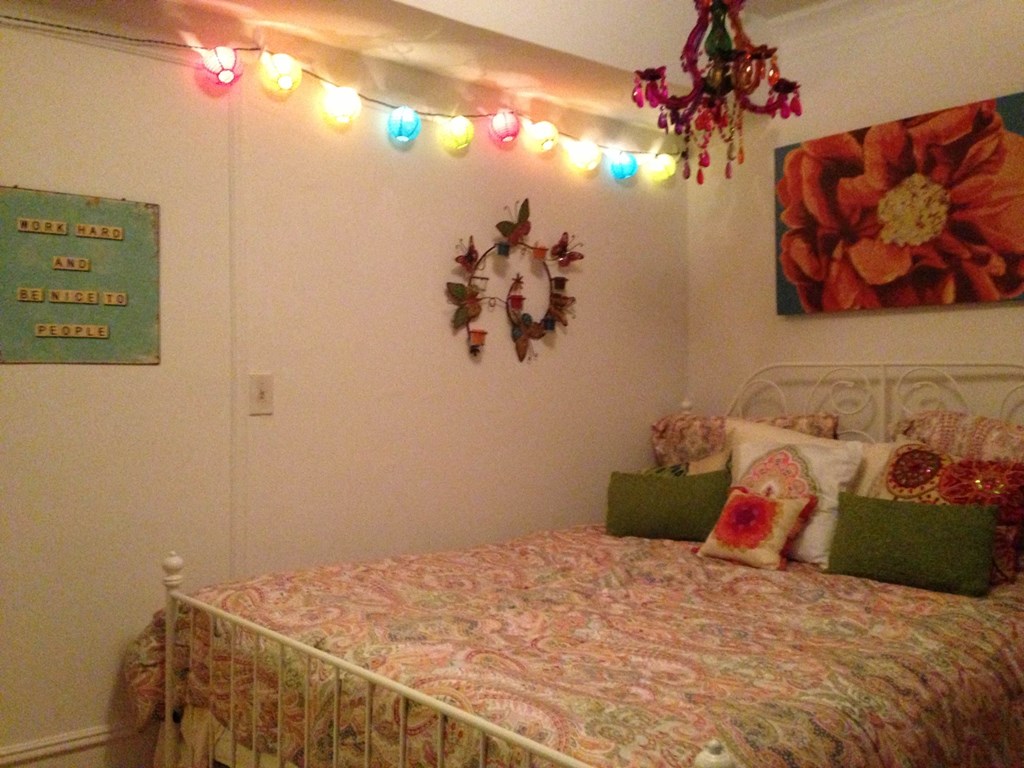 a bedroom with a bed and some lights on the wall