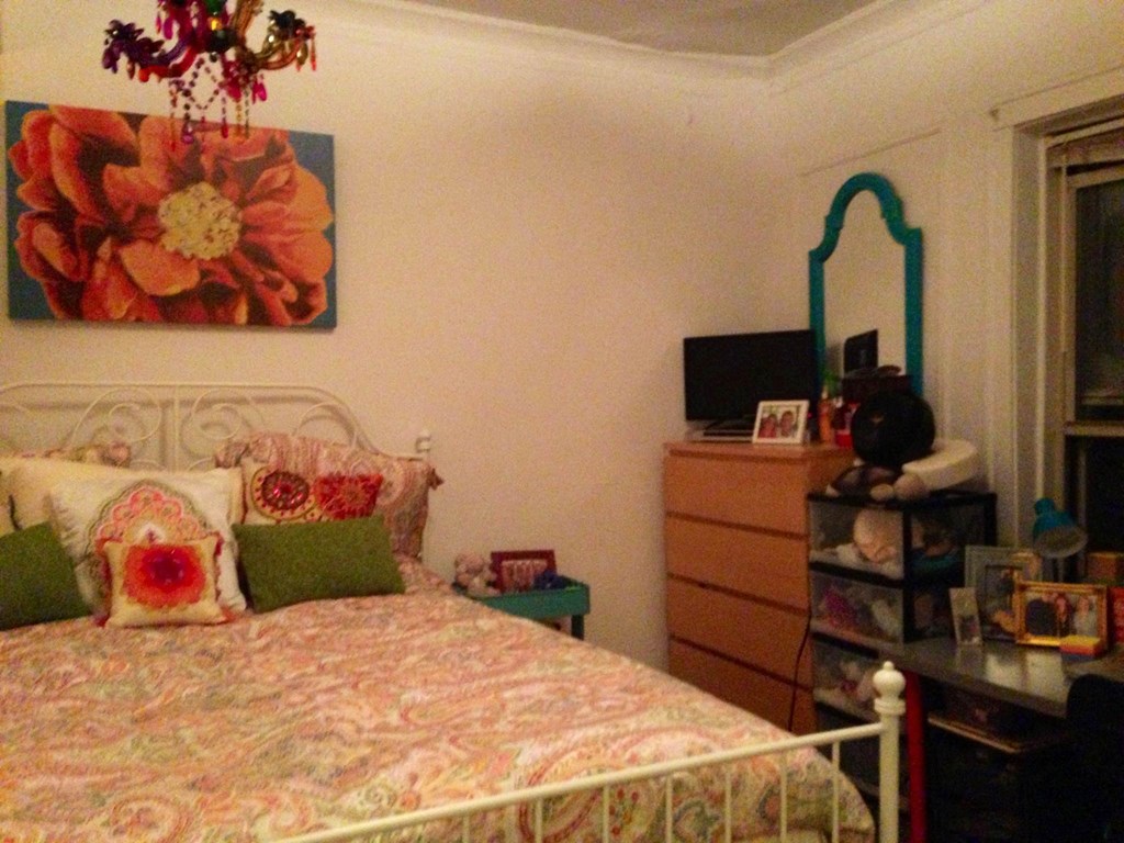 a bedroom with a bed and a dresser in it