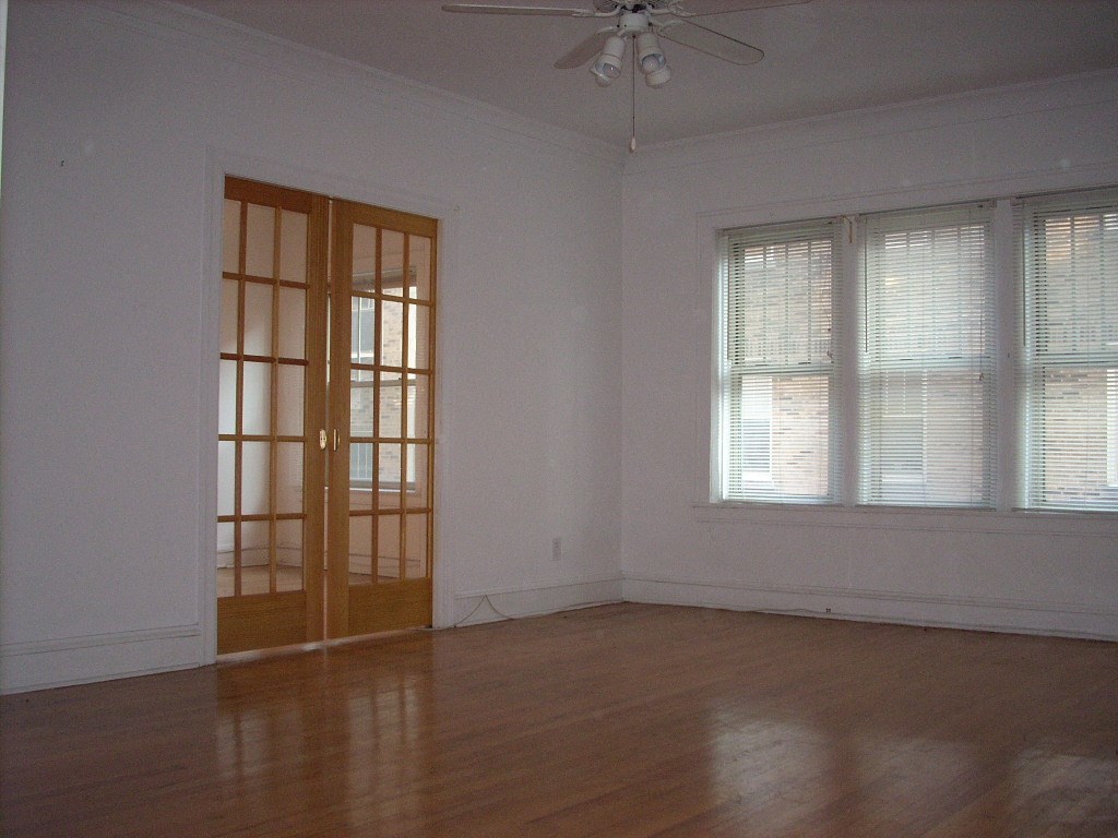 an empty living room with a door and window