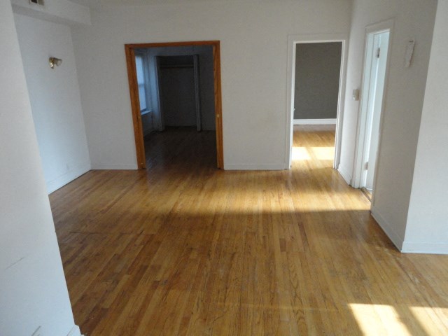a view from the living room into the hallway with wood floors