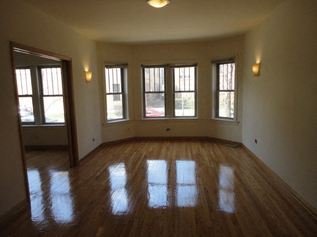 an empty living room with windows and a wooden floor