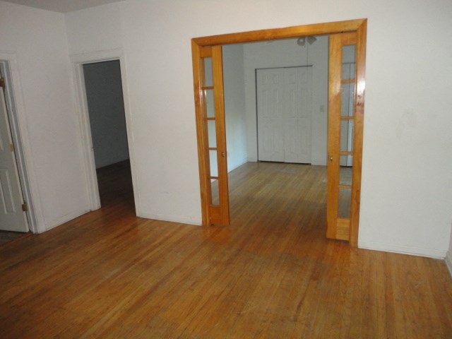 an empty living room with a wooden floor and an open doorway