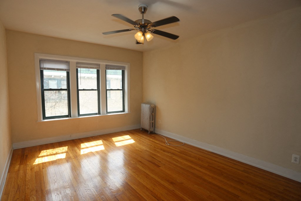 the living room of an empty house with a ceiling fan