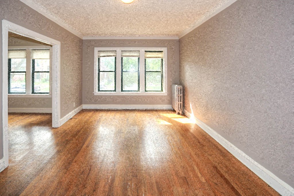 an empty living room with wood floors and a window