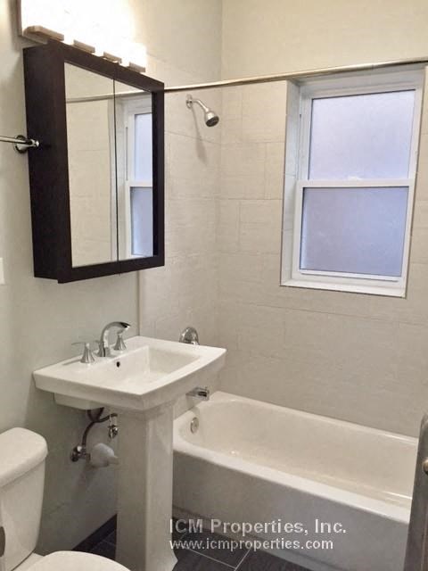 a white bathroom with a sink and a bath tub
