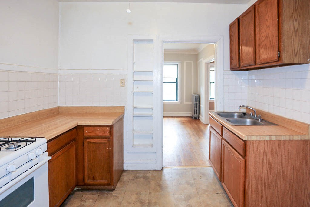 an empty kitchen with wooden cabinets and a stove