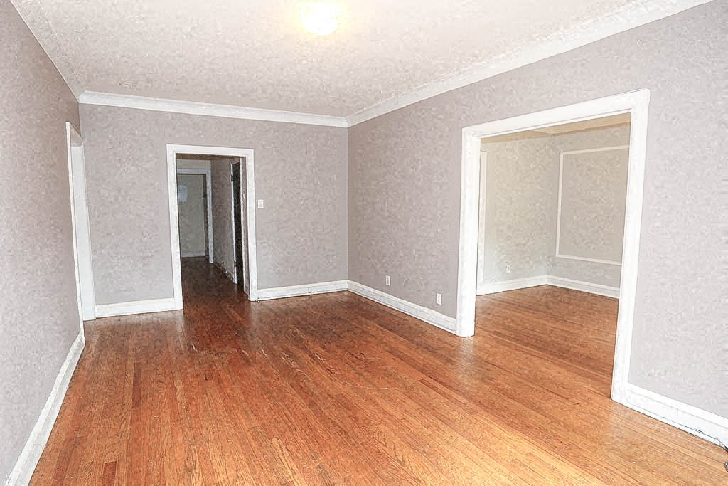 an empty living room with a wood floor