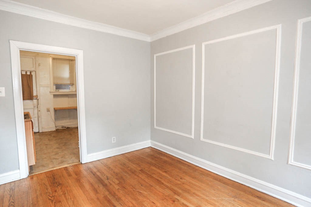 an empty living room with wooden floors and white walls