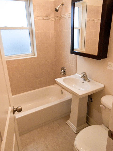 a white bathroom with a sink and a bath tub