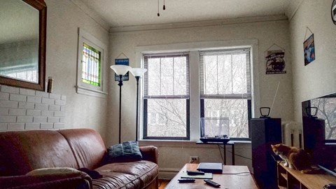 a living room with a leather couch and a window