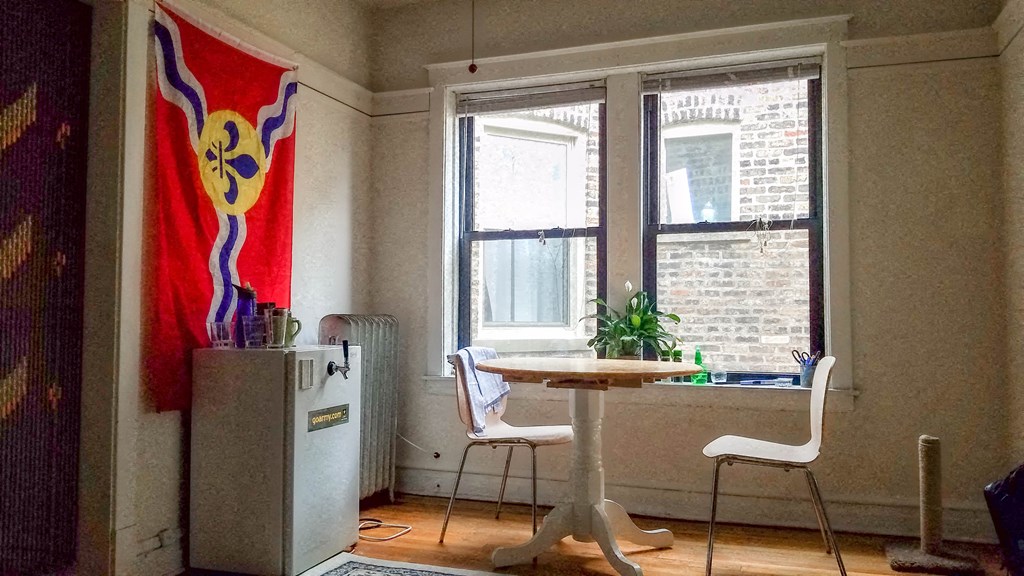 a dining room with a table and a chair in front of a window