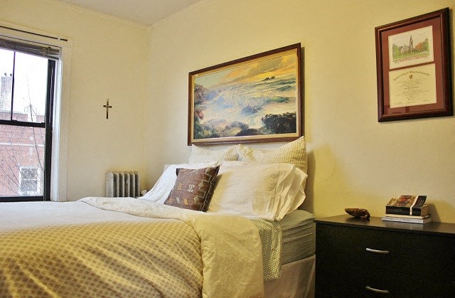 a bedroom with a bed and a painting on the wall