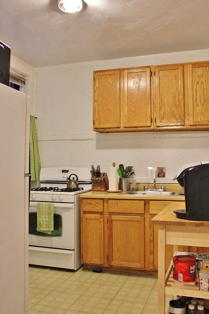 a kitchen with white appliances and wooden cabinets