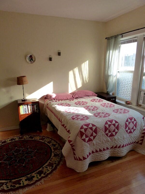 a bedroom with a bed with a quilt on it