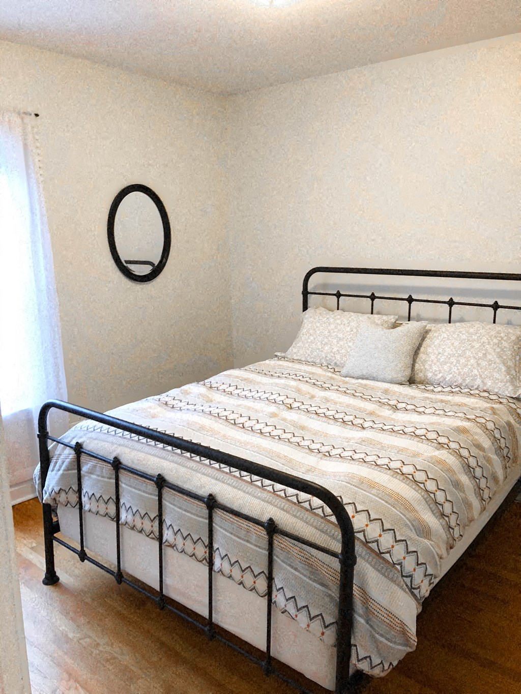 a bedroom with a bed and a mirror on the wall