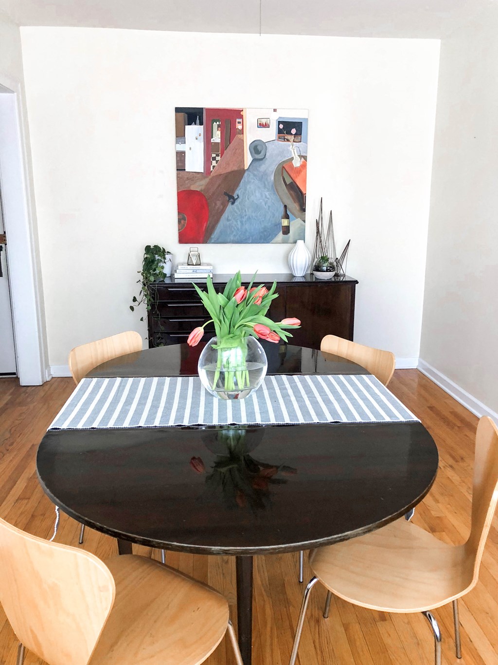 a dining room table with a vase of flowers on top of it