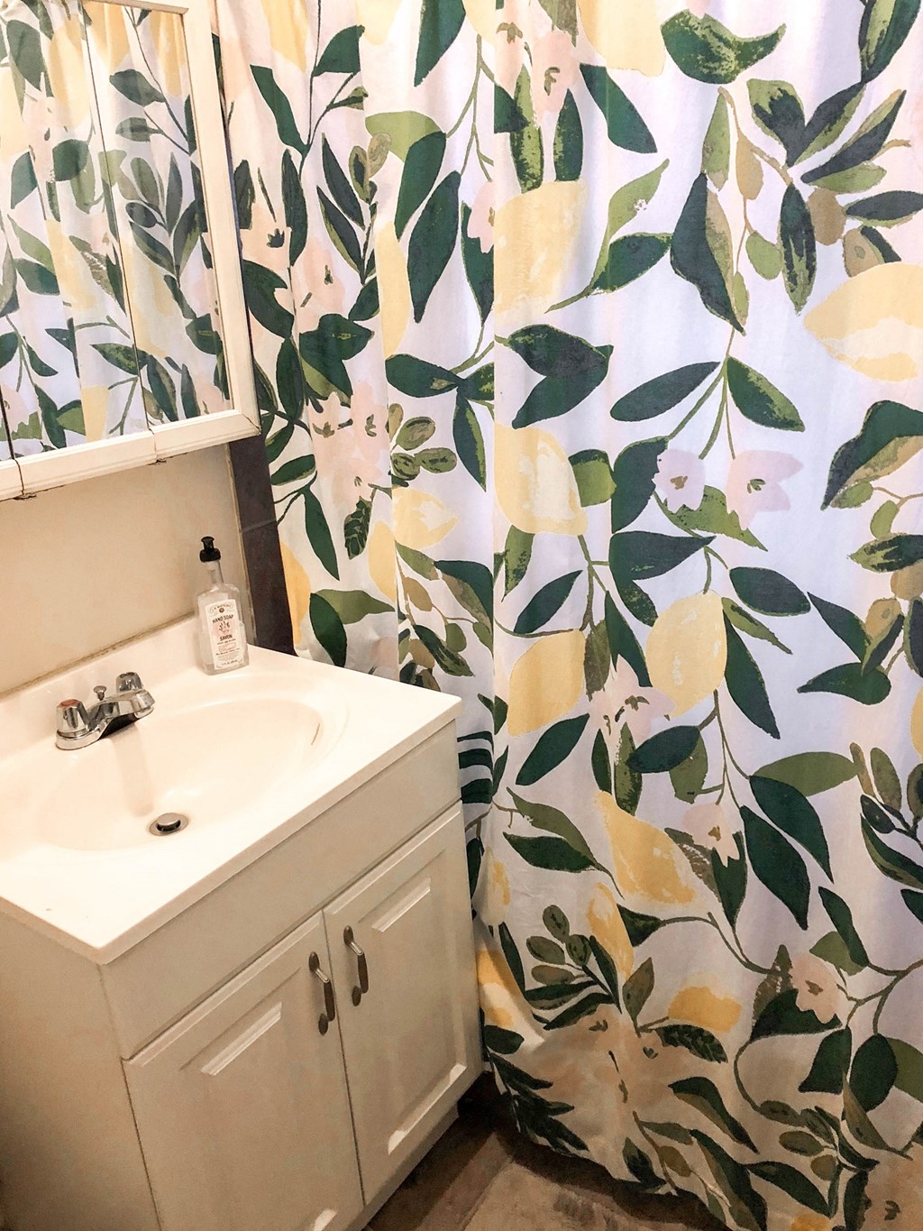 a small bathroom with a sink and a shower curtain