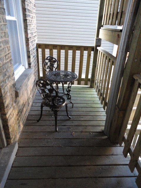 a patio with a table and chairs on a porch