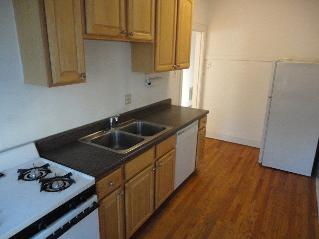 a kitchen with a stove and sink and a refrigerator