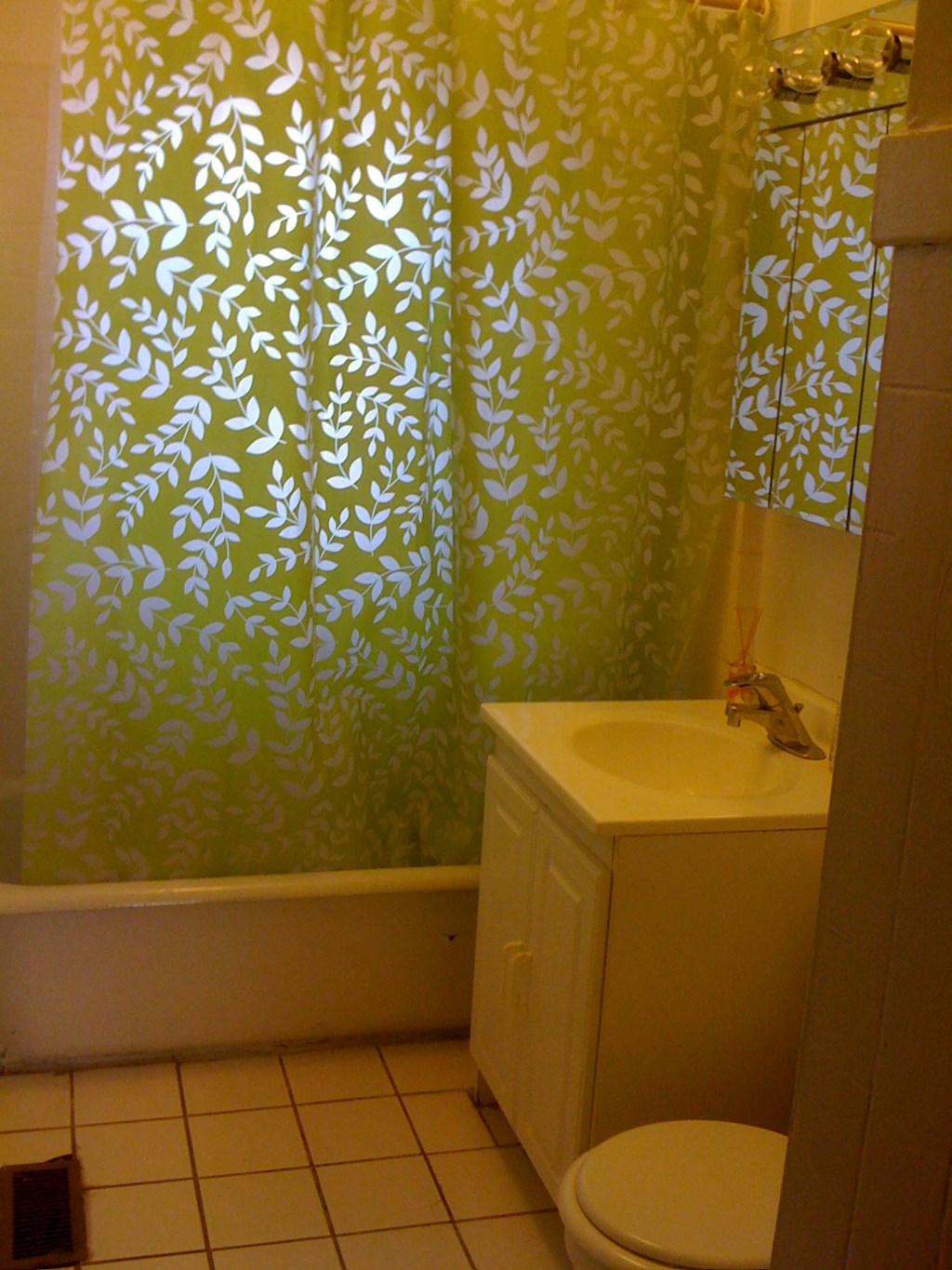 a bathroom with a toilet and a sink and a shower curtain