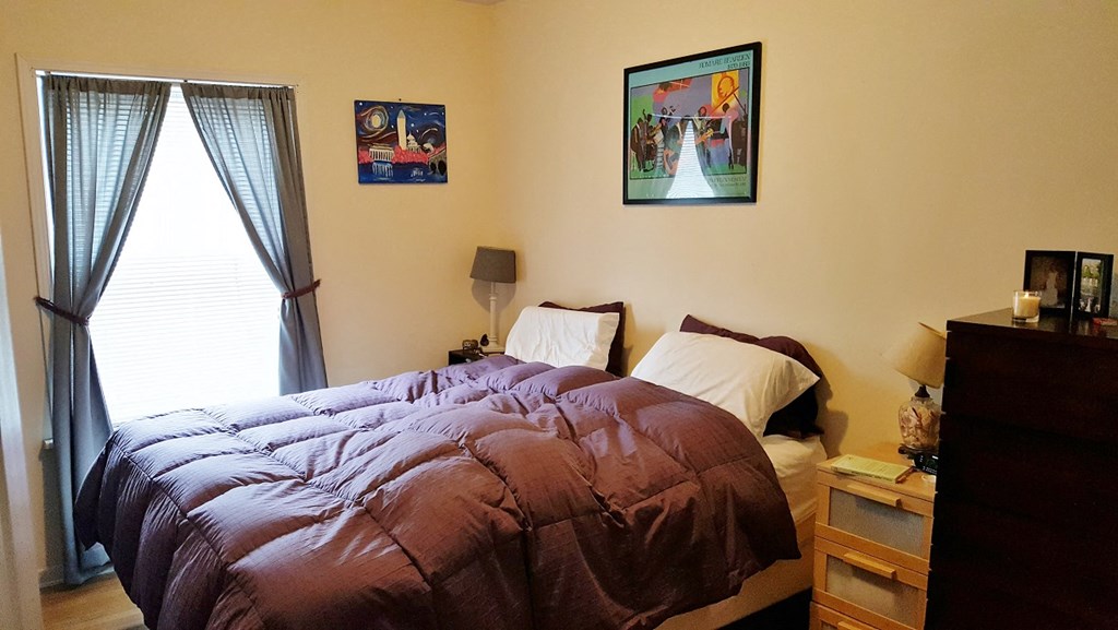 a bedroom with a bed and a picture on the wall