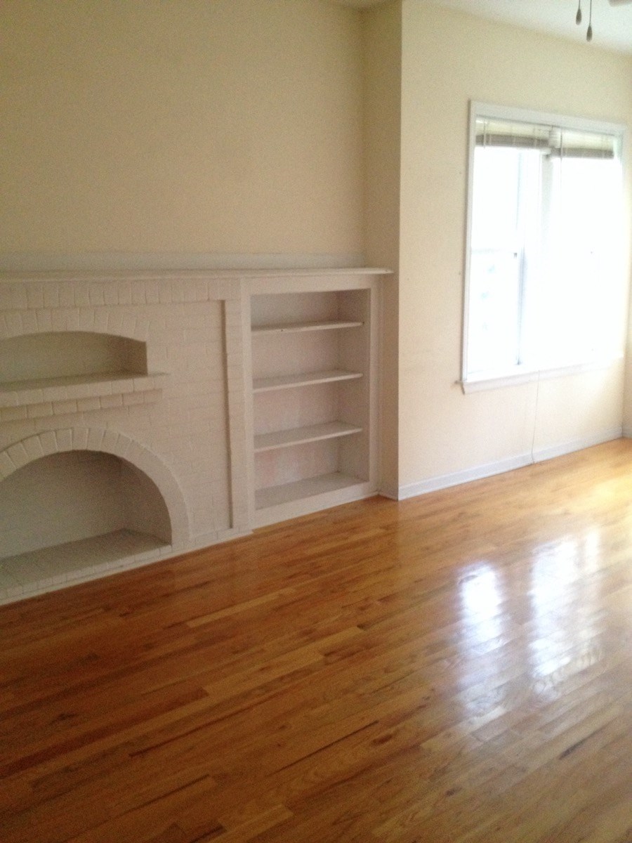 a living room with a fireplace and a wooden floor