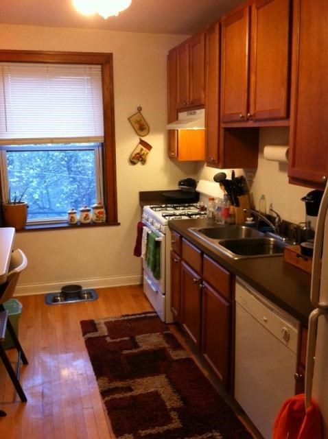 a kitchen with a stove and a sink and a window